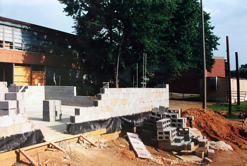 Photograph of a new classroom wing under construction.